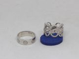 two silver rings and a blue ring on a white surface