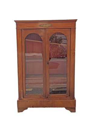 a wooden cabinet with two glass doors and a rug on the floor