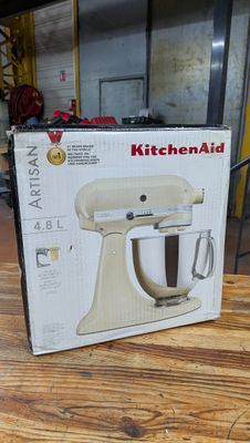 Robot pâtissier KitchenAid dans son emballage, posé sur une table dans la cuisine d'une maison