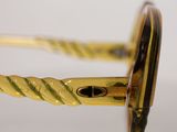 the glasses are shiny and shiny gold with a black rim