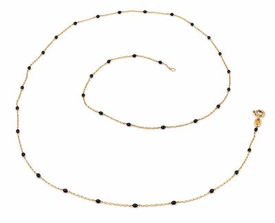 un collier composé de perles noires et d'une chaîne dorée