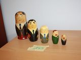 five wooden figurines of people on a wooden table