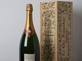 the bottle of champagne is next to a wooden box on a table