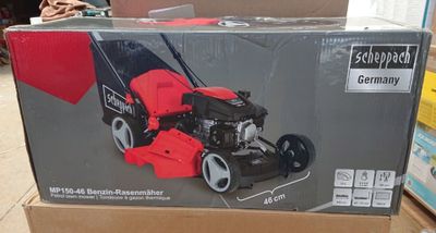 Le carton d'une tondeuse à gazon est posé par terre dans le magasin.