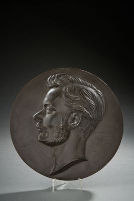 a close up of a bronze plate with a man ' s face
