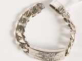 silver bracelet with engraved message on it on a white surface