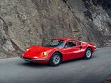 red sports car driving down a mountain road next to a cliff
