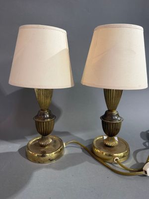 une paire de lampes de table en laiton, chacune dotée d'un abat-jour blanc