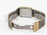 a silver and gold watch on a bracelet on a white surface