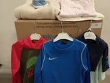 a pile of clothes on a rack in front of a wall