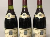 trois bouteilles de vin posées sur une table l'une à côté de l'autre