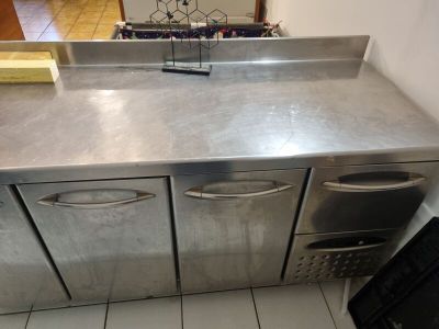 a stainless steel counter top in a kitchen with a microwave and dishwasher