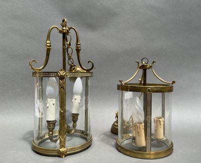 pair of brass and glass lanterns with candles inside of them
