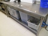 une grande table en acier inoxydable surmontée de bacs