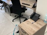 un bureau équipé de deux bureaux, d'un téléphone et d'un autre téléphone posé par terre