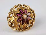 une image représentant une bague en or ornée d'un motif floral et d'une perle au centre