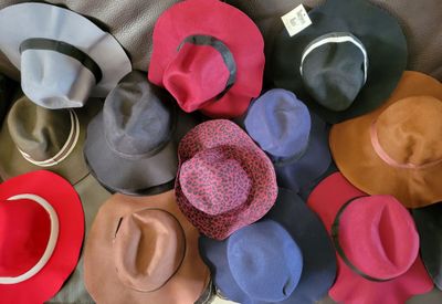 many hats that are sitting on a bed together