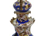 a blue and white vase with a bird on top of it