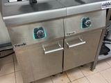 stainless steel counter top with two deep fryers on each side of it