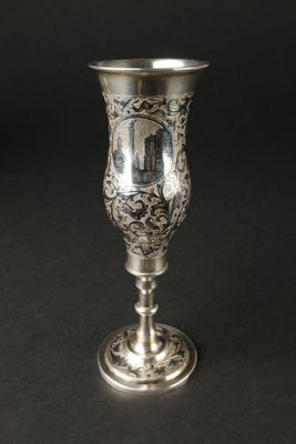 une coupe en argent ancienne posée sur une table noire