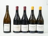 six bouteilles de vin sont alignées sur une table