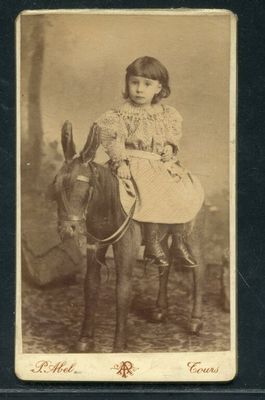 une vieille photo d'une petite fille à dos d'âne