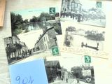 de nombreuses cartes postales anciennes posées sur une table, avec un stylo et du papier
