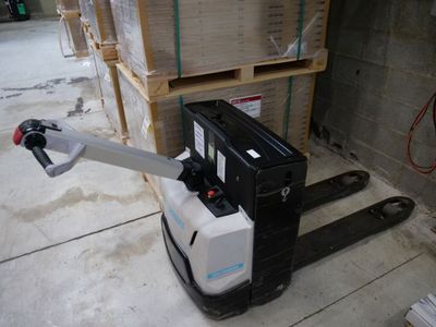 un chariot élévateur qui se trouve au milieu d'un entrepôt