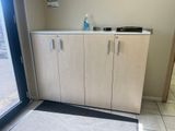 une armoire avec une porte et un paillasson posé au sol