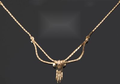 Gros plan sur un collier en or orné d'un oiseau