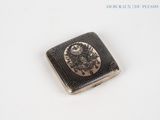 a small metal object with a picture on it