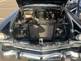 a black car with its hood open and the engine in it ' s trunk
