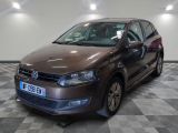the brown volkswagen polo is parked on a checkered tile floor