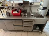 a large stainless steel kitchen with a sink and a stove