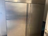 a stainless steel refrigerator in a kitchen with tiled flooring
