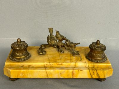 brass figurines of birds on a marble base with bells