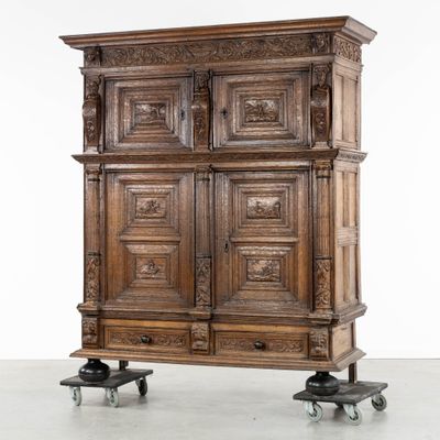 une photo montrant une grande armoire en bois montée sur roulettes dans une pièce