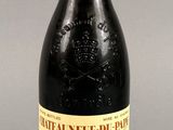 une bouteille de vin rouge posée sur une table à côté d'un verre de vin