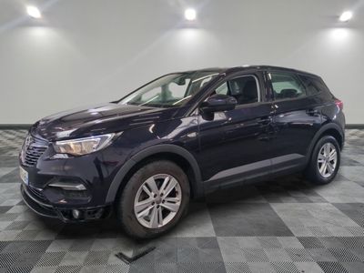 une voiture bleue est garée sur le sol à carreaux d'un garage