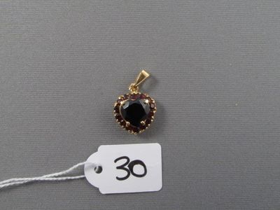 une photo d'un pendentif en or serti de grenats, avec une étiquette de prix