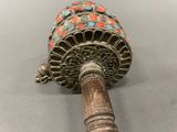 a small metal bell with a wooden handle on a table