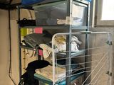 an image of a room that has a rack with clothes on it