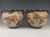 pair of vases with a painting of a man and woman in a landscape