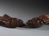pair of brown shoes on a gray surface with a light in the background
