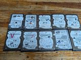Plusieurs disques durs sont empilés les uns sur les autres sur une table en bois