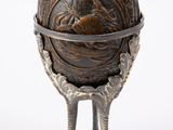 a small metal object with a bird ' s feet on it