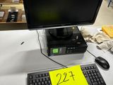 un écran d'ordinateur et un clavier posés sur un bureau dans un entrepôt
