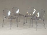 trois chaises en plastique transparent placées les unes à côté des autres sur une surface blanche