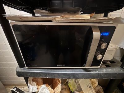 un micro-ondes posé sur une étagère