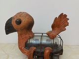 statue of a bird with a cage on its back sitting on a table